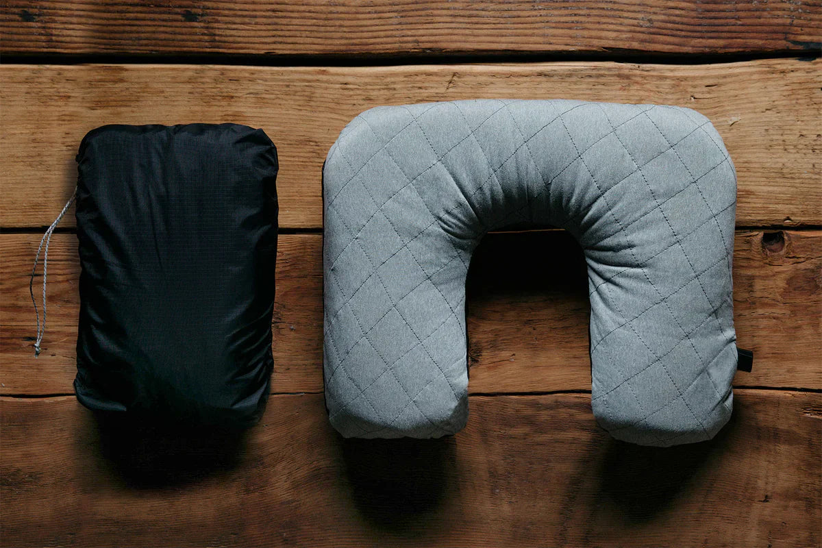 Stylish gray neck pillow on a wood table.
