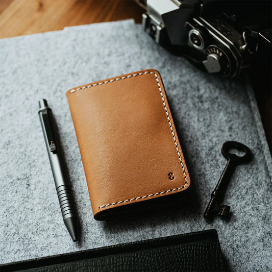 A collection of high-quality men's everyday carry items, including a minimalist wallet, Grafton Pen, multitool, and keychain, arranged on a modern surface.