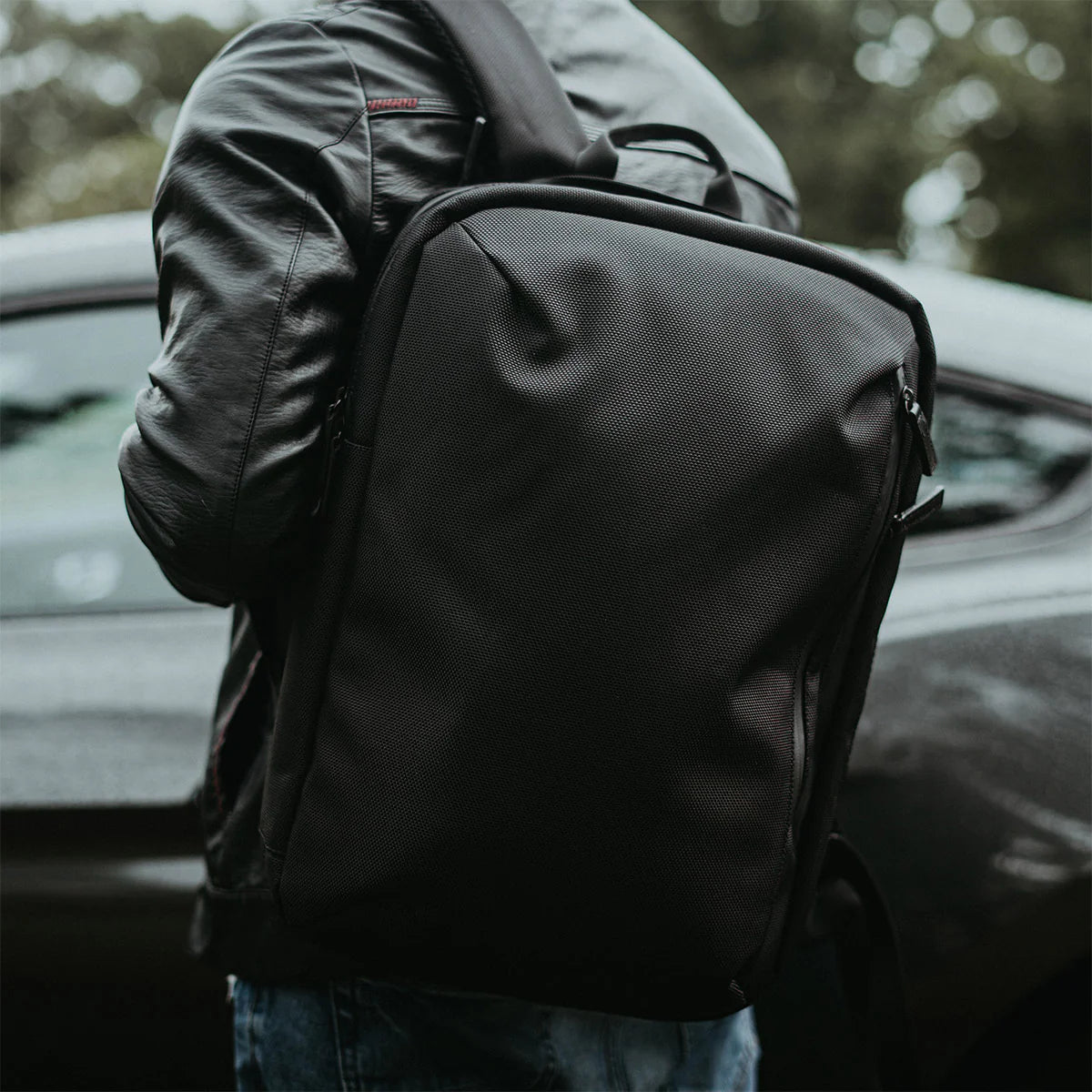 A stylish, durable backpack with high-quality everyday carry items set against an urban and outdoor backdrop.