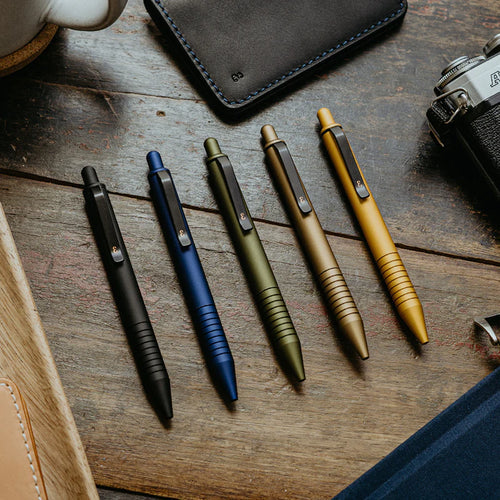 A modern, minimalist workspace featuring sleek Mini Pen, Original Grafton Pen, and a minimalist Holden Wallet.