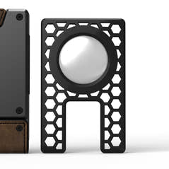 PROOF AirTag holder: a black hex-lattice insert with a circular seat holding an AirTag, standing beside a PROOF wallet