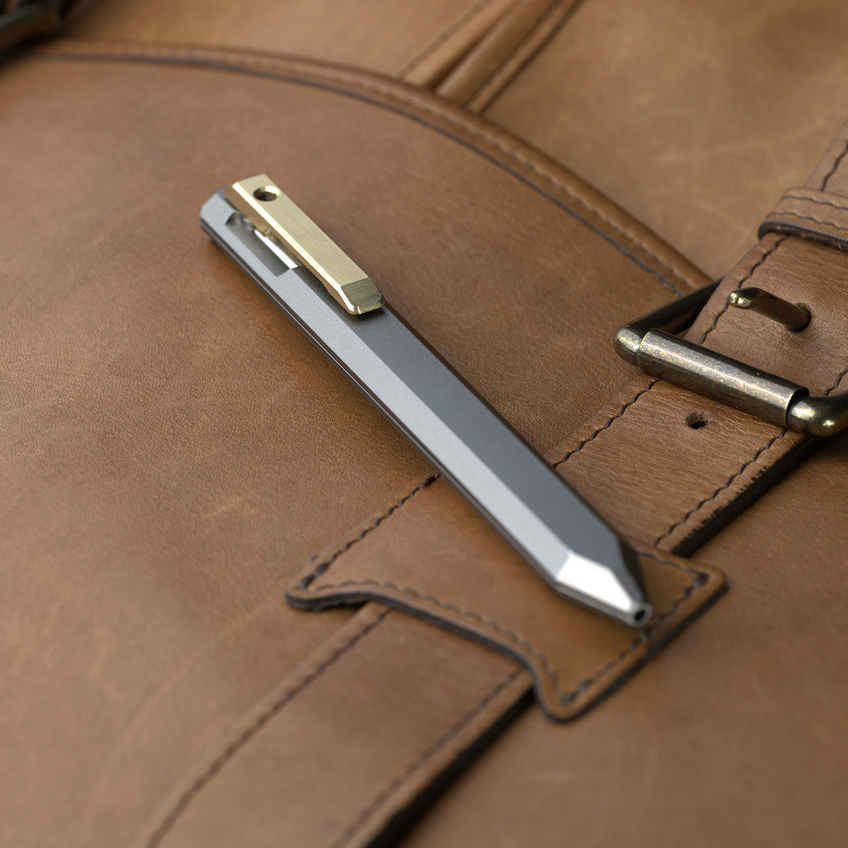 PROOF Vanguard pen clipped to the flap of a brown leather bag