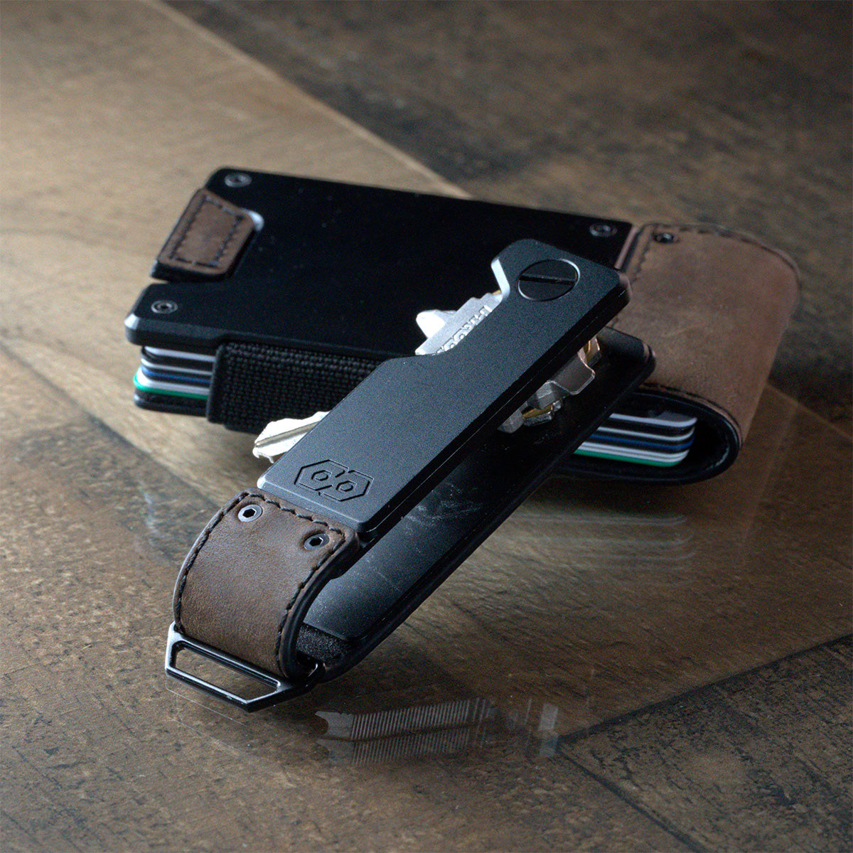 PROOF Founder key holder resting against a PROOF wallet on wood decking, keys and multi-tool partly swung out