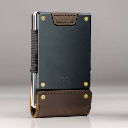 A PROOF wallet standing upright with gold bolts fitted at all four corners, showing how the hardware changes the look