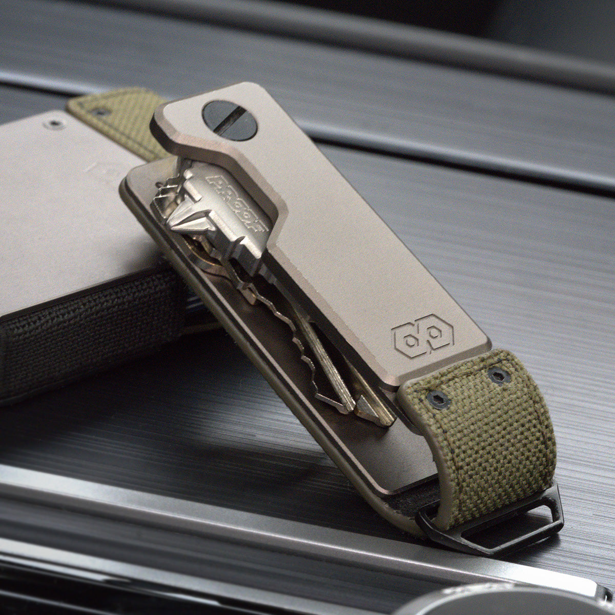 PROOF Operator key holder standing on brushed metal with its keys splayed from the satin aluminum body