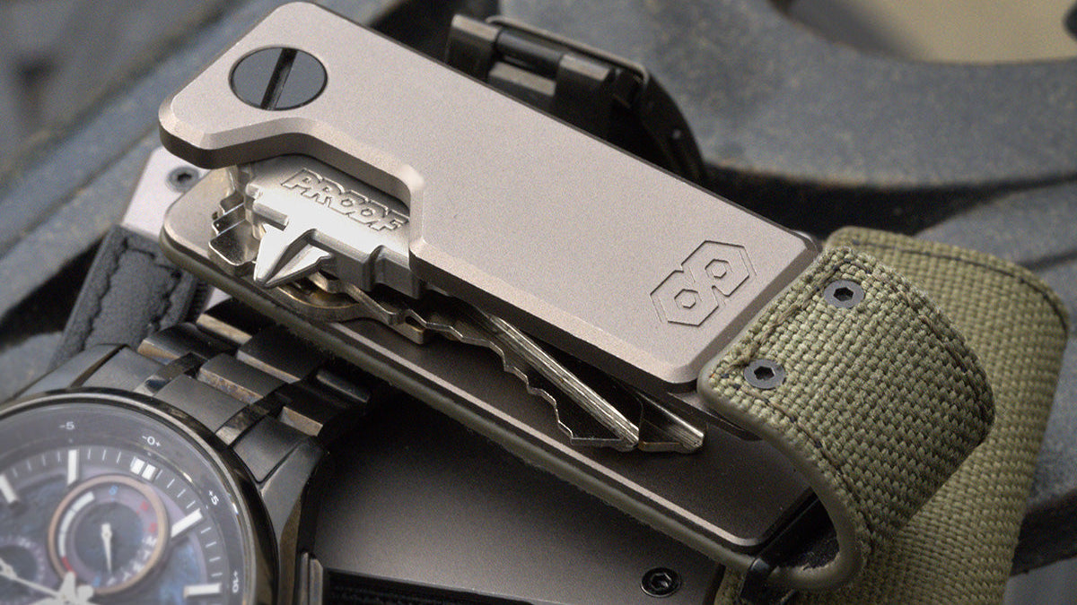 PROOF Operator key holder with keys and multi-tool deployed, lying beside a dark wristwatch