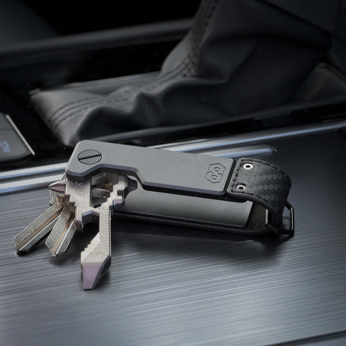PROOF Oracle key holder open on a vehicle console with three keys and a key-shaped multi-tool fanned out