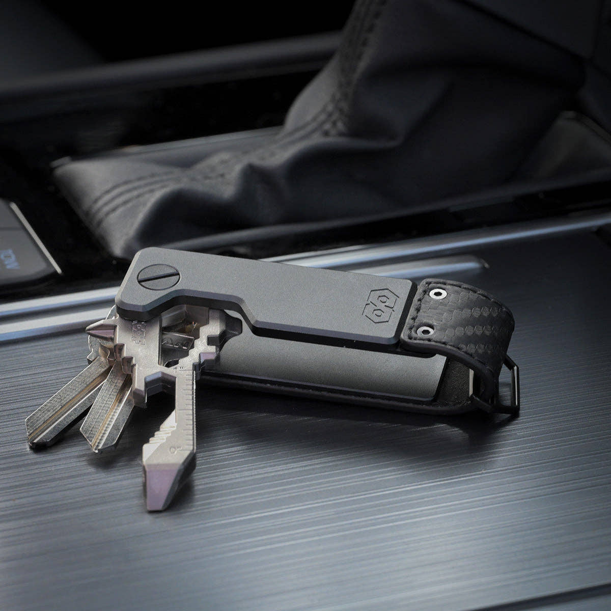 PROOF Oracle key holder open on a vehicle console with three keys and a key-shaped multi-tool fanned out