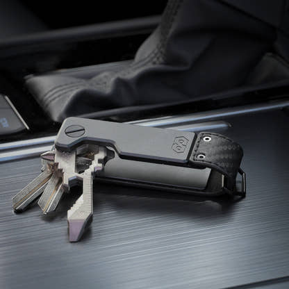 PROOF Oracle key holder open on a vehicle console with three keys and a key-shaped multi-tool fanned out