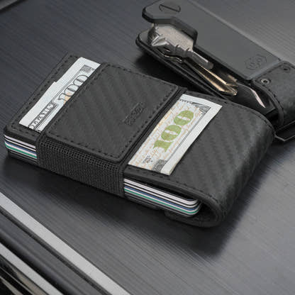 PROOF Oracle carbon fiber wallet with folded bills secured under the exterior elastic cash strap