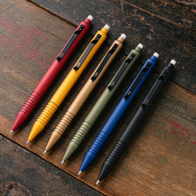 Set of six multicolored metal EDC Mechanical pencils on a wooden surface