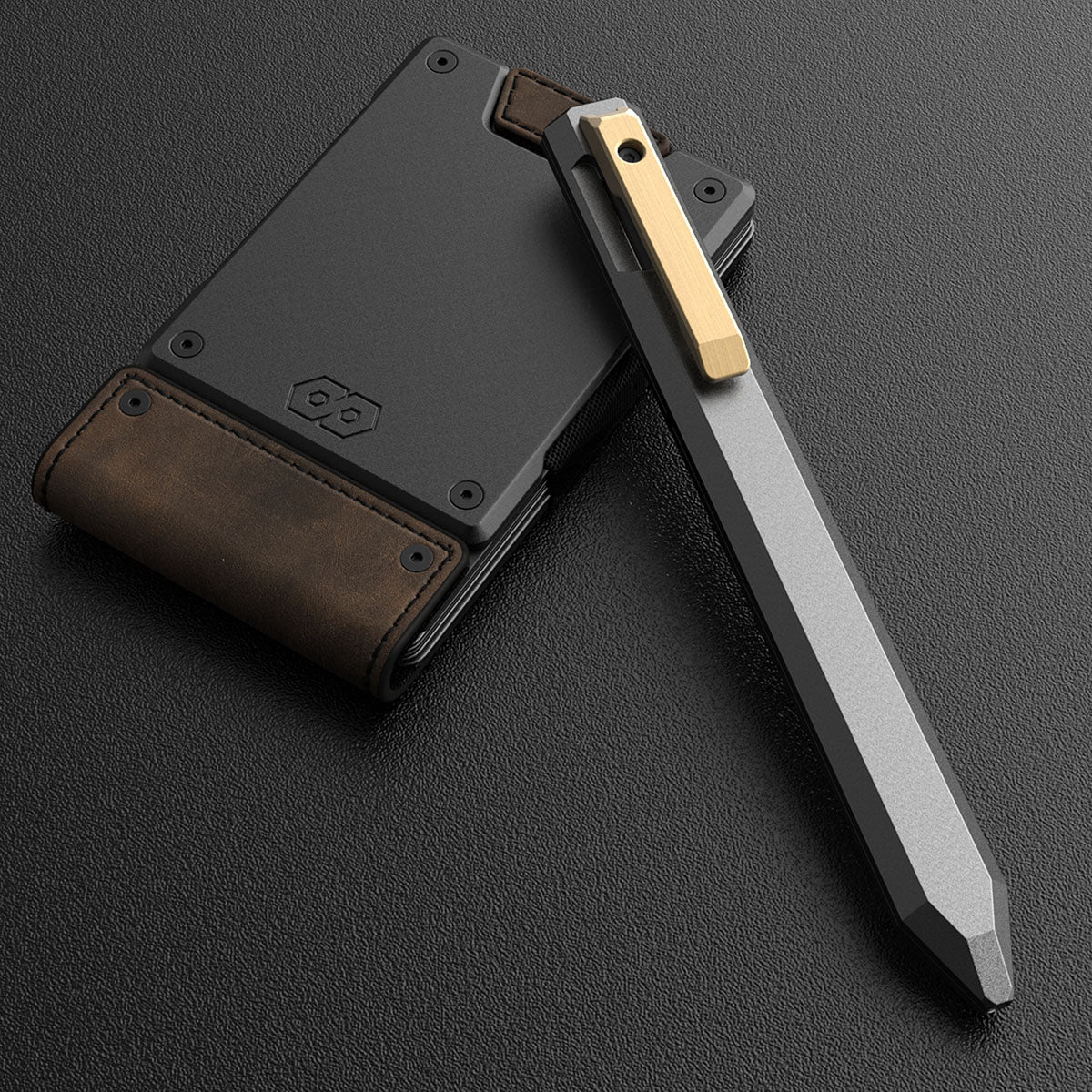 PROOF Vanguard pen leaning against a PROOF wallet with a black plate and brown leather, on a black surface