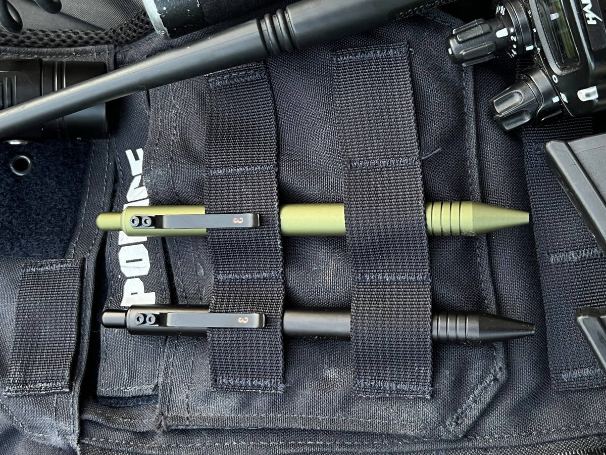 OD Green and Black Super Matte Graftons in the MOLLE webbing of a police vest