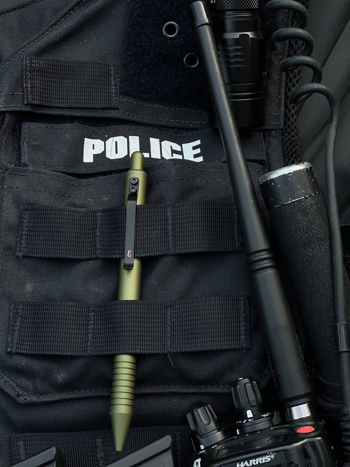 OD Green Super Matte Grafton clipped in the MOLLE webbing of a police vest