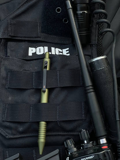OD Green Super Matte Grafton clipped in the MOLLE webbing of a police vest