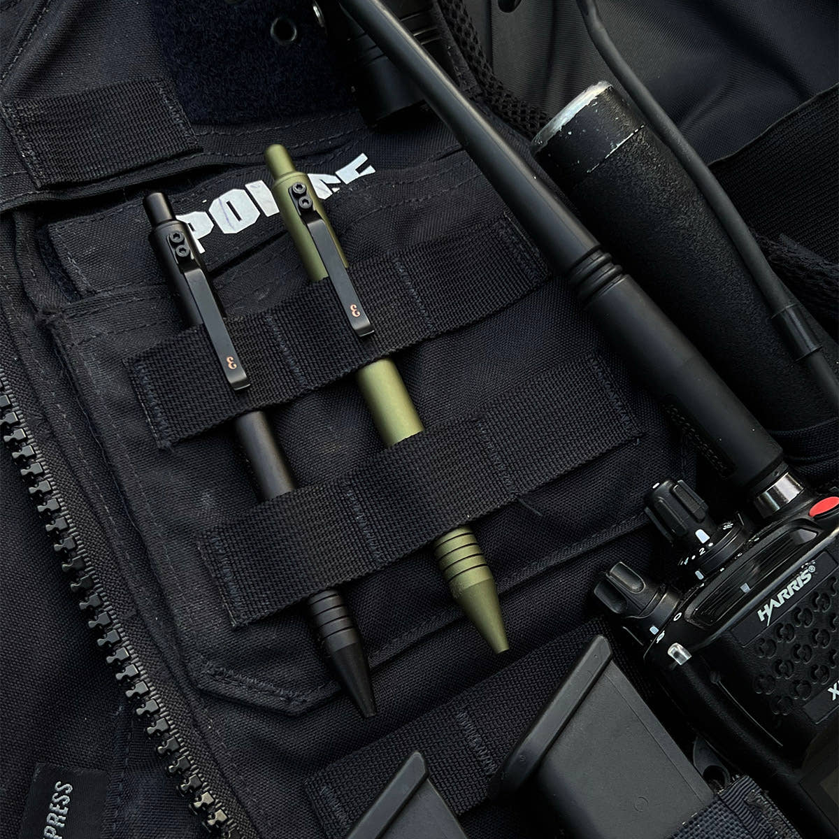 OD Green and Black Super Matte Graftons carried in the MOLLE webbing of a police vest