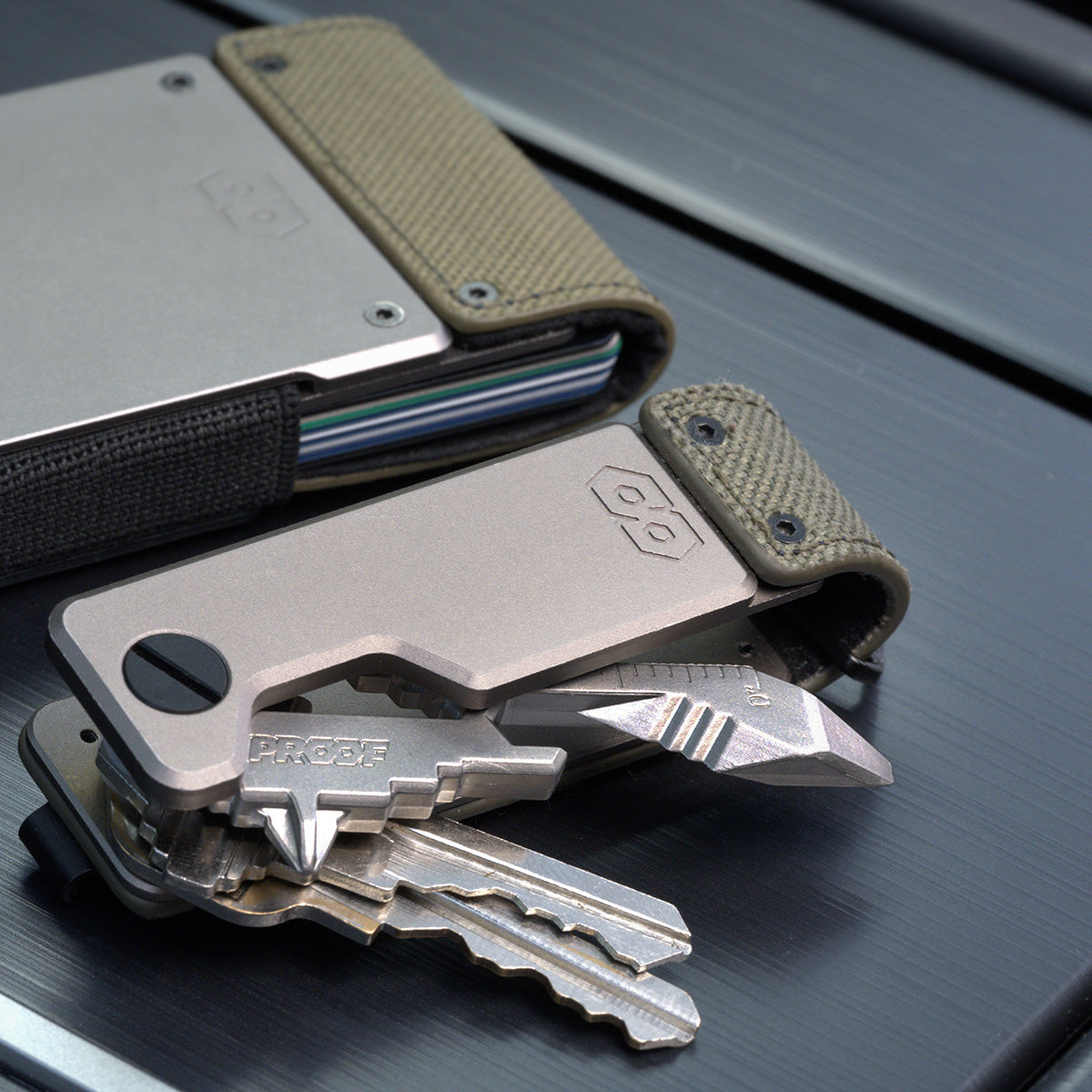 PROOF Operator key holder open beside a PROOF wallet, keys and a key-shaped multi-tool fanned from the satin aluminum body